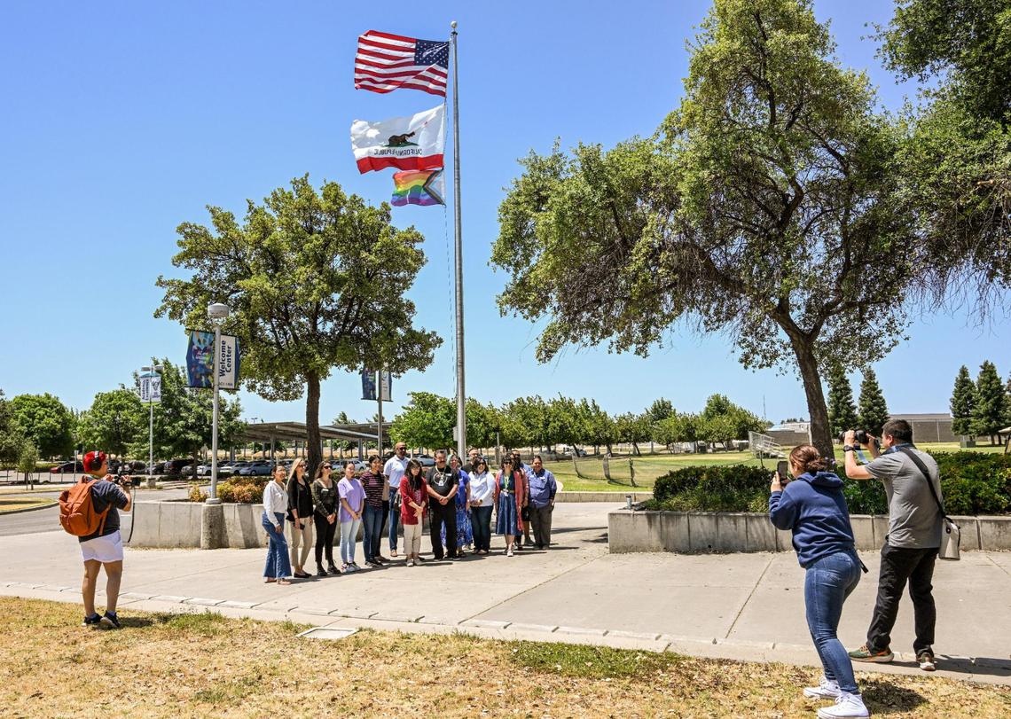 Students and staff gather by the the flag pole at Clovis Community College in Clovis for photos following a ceremony to recognize June as Pride Month at the campus on Thursday, June 1, 2023.