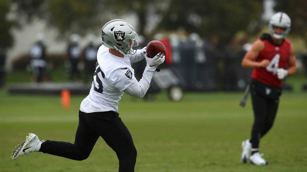 Oakland Raiders' Ryan Switzer, left, makes a catch on a pass from Derek Carr (4) during NFL football practice on Tuesday, May 22, 2018, at the team's training facility in Alameda, Calif.