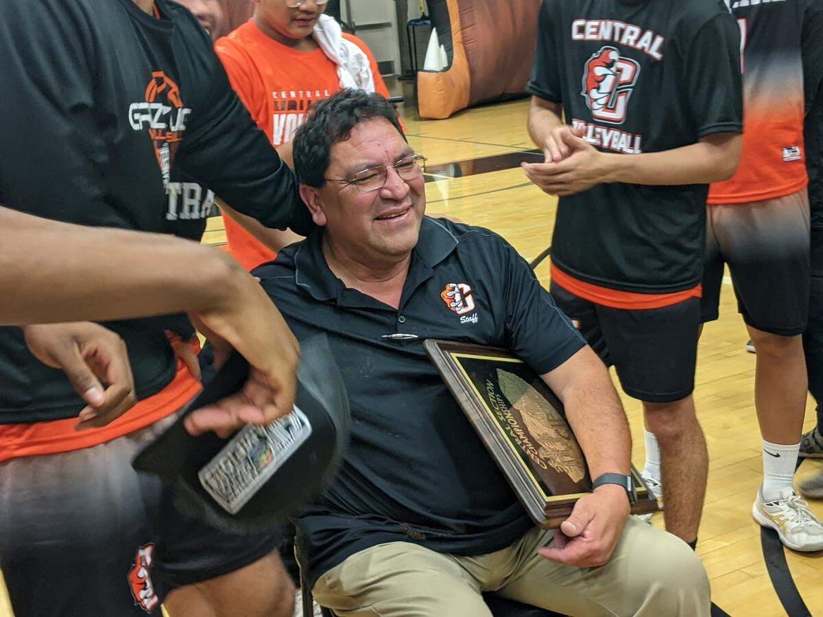Central High boys volleyball coach Darin Williams holds the championship plaque after his Grizzlies won a section title.