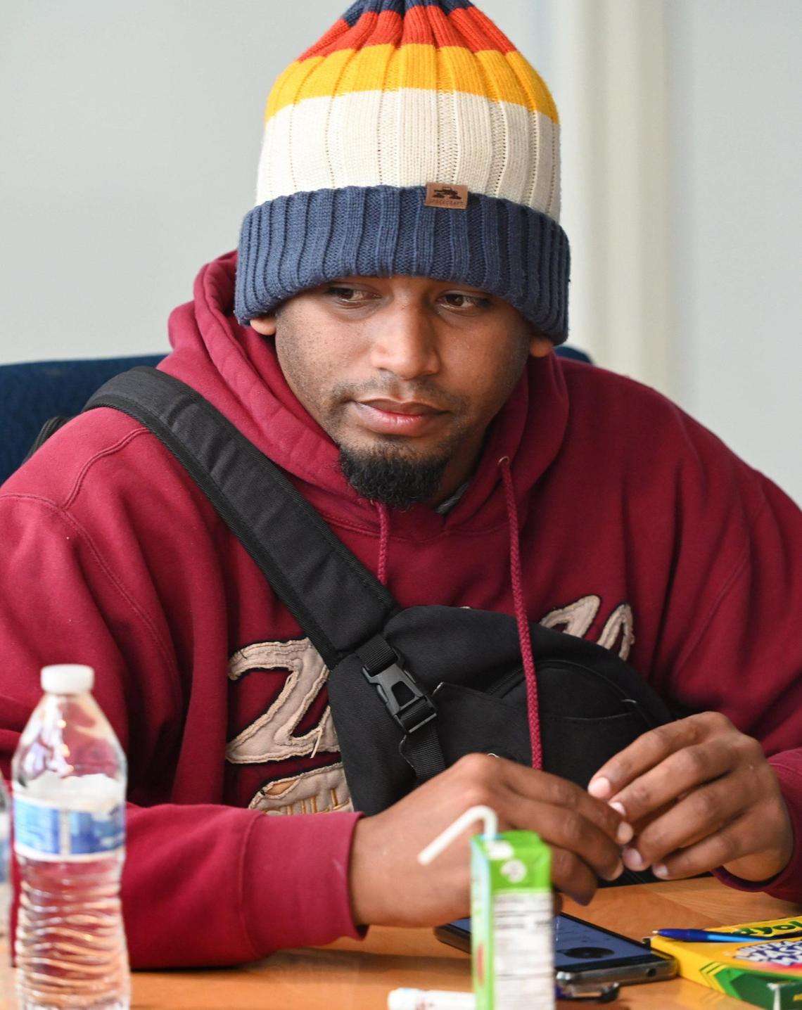 One of the 16-20 asylum seekers who arrived in Fresno last Saturday, sits with others at Fresno City hall to get information from city officials and social workers on Friday, Feb. 2, 2024.