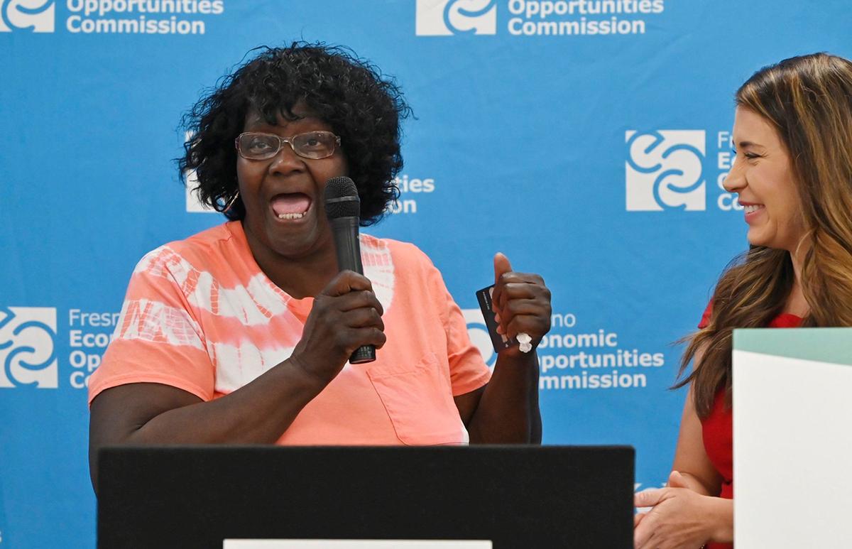 Agarrando una tarjeta de pago en su mano izquierda, una emocionada Patricia Cail, a la izquierda, agradece a EOC y a sus patrocinadores por haber sido seleccionada para recibir $500 al mes durante un año mientras la anfitriona Amanda Venegas está a la derecha, en el evento oficial de lanzamiento del programa Advancing Fresno County Guaranteed Income, el miércoles 17 de julio de 2024, en Fresno. El programa proporcionará $500 al mes durante un año a 150 familias sorteadas para ayudar a combatir la pobreza.