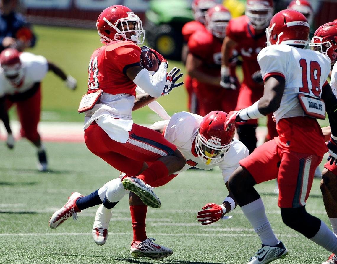 Fresno State wide receiver Justin Allen, foreground, spins clear of a tackle during Spring Preview, capping off spring football training in front of fans at Bulldog Stadium Saturday, April 29, 2017 in Fresno.
