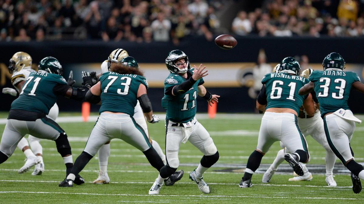 Philadelphia Eagles quarterback Carson Wentz (11) bobbles a high snap on fourth down in a 48-7 loss to the New Orleans Saints in New Orleans, Sunday, Nov. 18, 2018. The defending Super Bowl champions are averaging 20.5 points per game, one season after averaging 28.7 in the regular season.