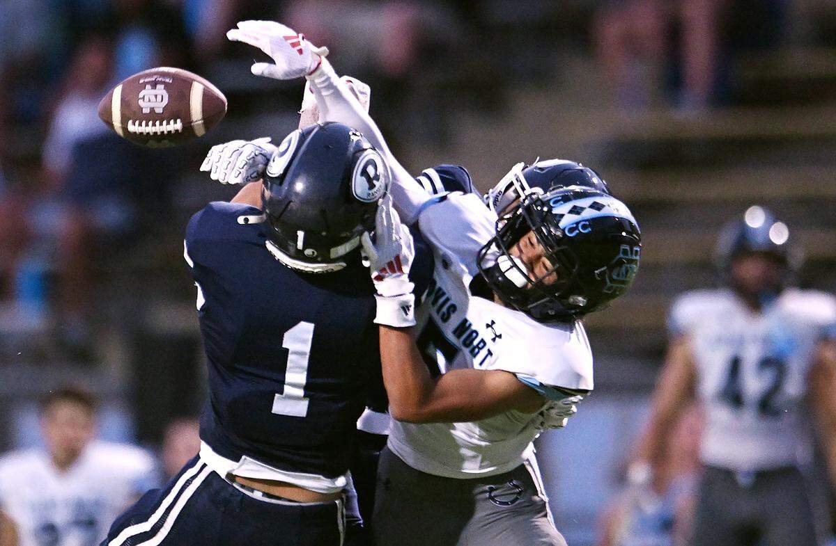 Redwood High's Luke Sanchez, left, and Troy Harris, background, break up a pass intended for Clovis North's David Williams, right, in a game Friday, Aug. 29, 2025 in Visalia. Clovis North held off Redwood for a 38-34 win.