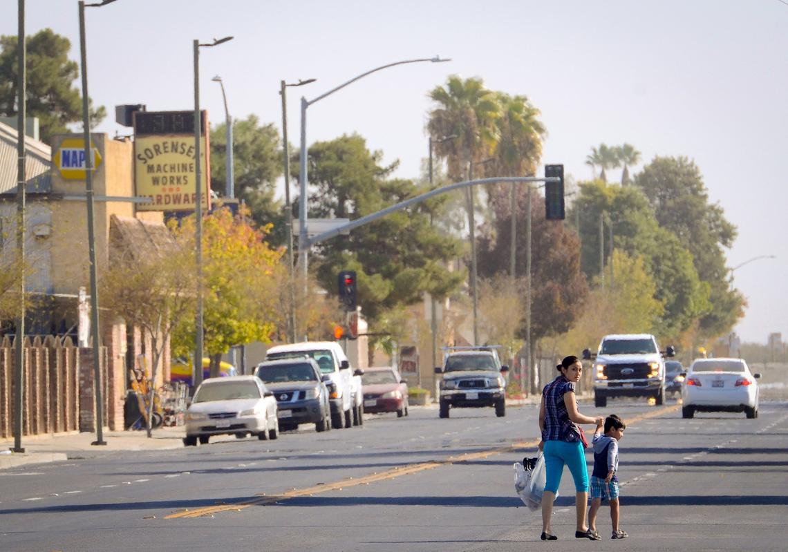 A mother and son cross Oller Street in the somewhat quiet western Fresno County city of Mendota.