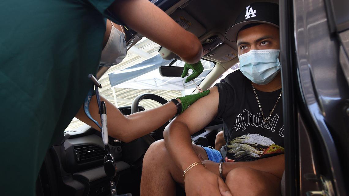 Antonio Diaz gets his second dose of COVID-19 Pfizer vaccine from UCSF medical clerk Alex Chavez, Friday May 7, 2021, at the UCSF Covid Equity Project’s drive-up clinic at Fresno City College.