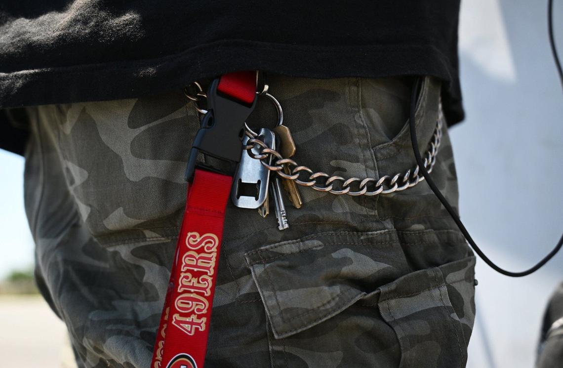 A chain secures Gabriel Carpio’s walet as he works along Blackstone Ave. helping advertise for USA Furniture by holding and twisting a sign along the sidewalk. Photographed Wednesday, May 29, 2024 in Fresno.
