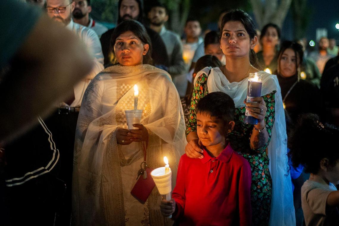Sukhjeet Kaur, 28, of Fresno, places her hand on the shoulder of son Nirmol Singh, 7, during a vigil for 8-month-old Aroohi Dheri, her parents Jasleen Kaur, 27, and Jasdeep Singh, 36, and her uncle Amandeep Singh, 39, at Bob Hart Square in Merced, Calif., on Thursday, Oct. 6, 2022. The bodies of the four kidnapping victims were found in a rural area of Merced County north of Dos Palos on Wednesday. Authorities said the family was kidnapped at gunpoint Monday from a Merced County business.