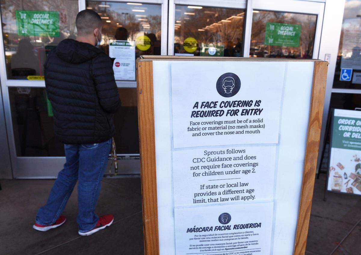 Reedley’s Andrew Chavez, an adjunct professor at Fresno State, peers at the closed doors of Sprouts Farmers Market after an anti-mask demonstration outside forced the store to close Saturday, Jan. 23, 2021 in Fresno.