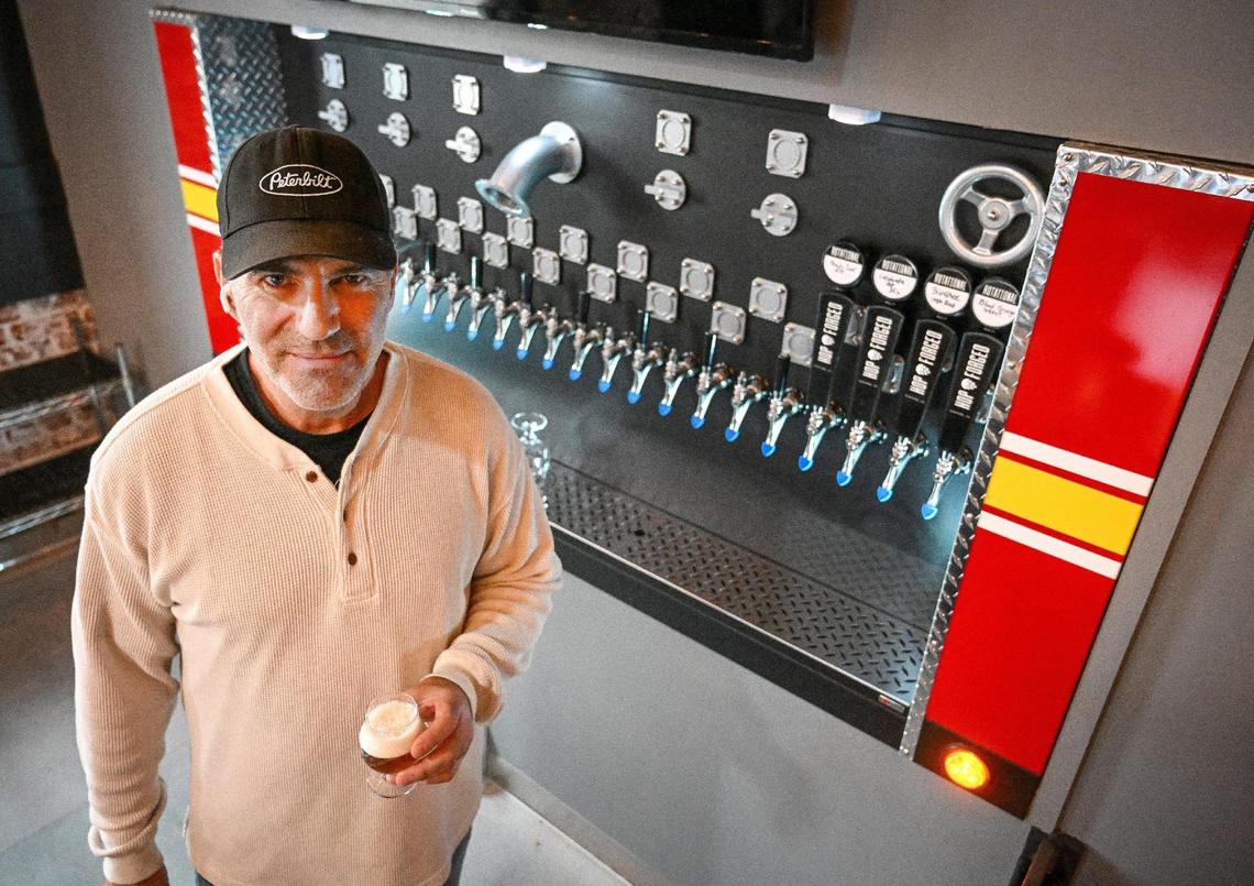 Richard Wadda, owner of Station 48 Taproom, stands at the fire engine control panel-themed tap wall with one of the local brews that will be available at the former fire station in downtown Fowler.