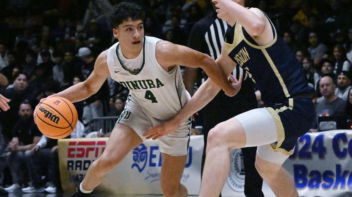 Dinuba’s Javier Torres, left, drives around Mission Prep’s Luke Jacobson, right, in the Division II game Friday, Feb. 23, 2024 in Fresno..