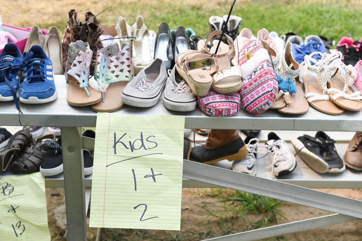 Donated shoes sit on bleacher seats at the Community Kick it Outreach shoe giveaway on Saturday, Aug. 7, 2021.