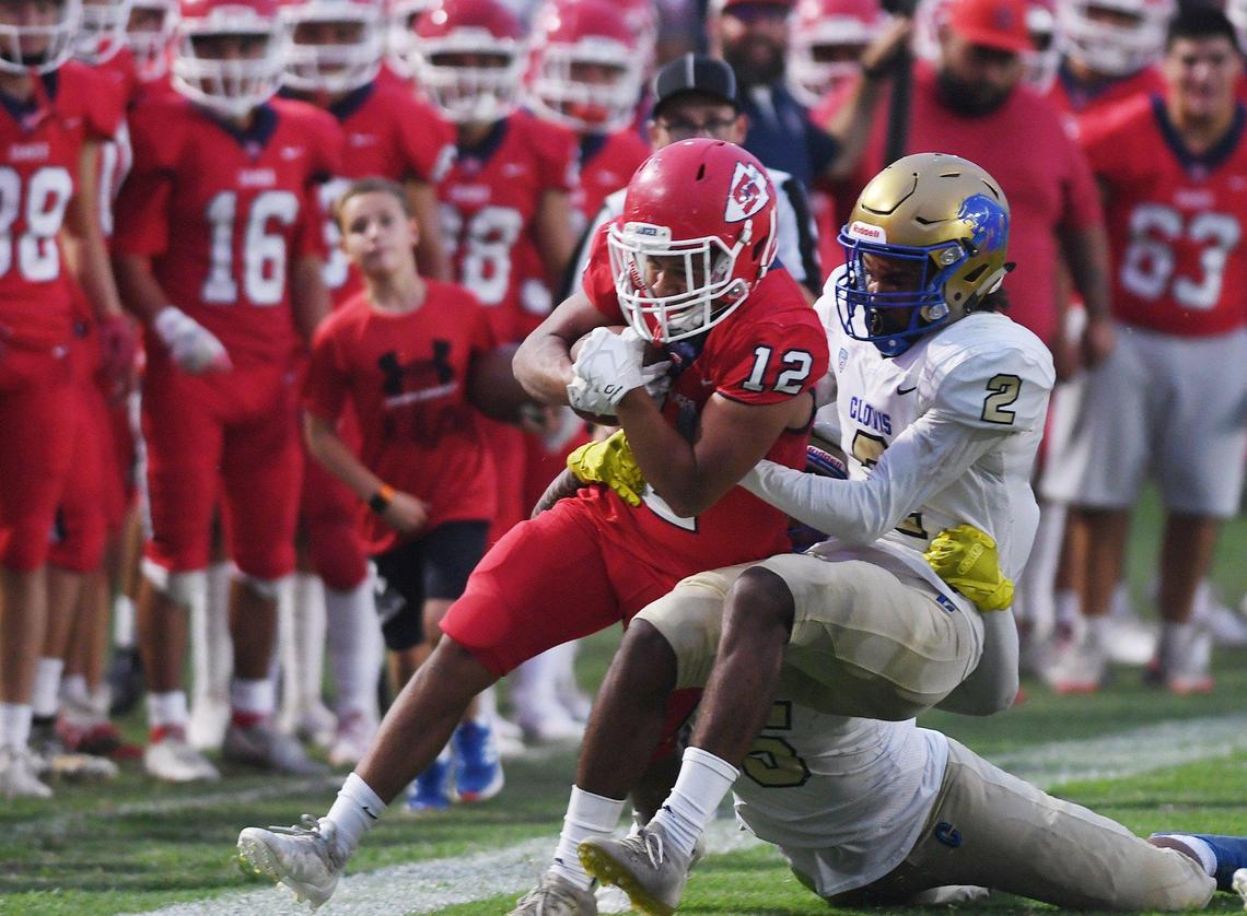 Sanger’s Jacob Gonzalez, left, is tackled by Clovis High’s Carlos Mack, right, Friday, Aug. 20, 2021 in Sanger. Clovis led 28-0 at halftime.