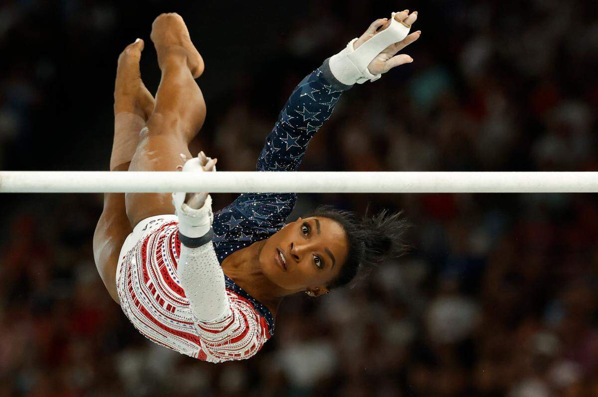 American gymnast Simone Biles performs in the uneven bars event during the Women’s Artistic Gymnastics Team Final, part of the Paris 2024 Olympic Games on Tuesday at the Bercy Arena in the French capital. / La gimnasta estadounidense Simone Biles en la prueba de Barras Asimétricas durante la final de Gimnasia Artística en Equipos Femenino, parte de los Juegos Olímpicos de París 2024 este martes, en el Bercy Arena de la capital francesa.