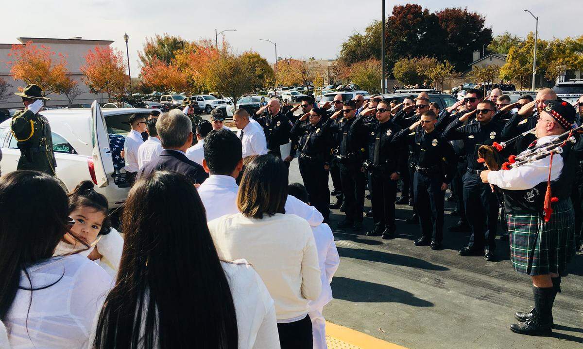 Pallbearers put the casket of Lemoore Police Officer Jonathan Diaz into a hearse outside Saint Peter Prince of the Apostles Catholic Church in Lemoore on Nov. 15, 2019 as law enforcement officials salute.