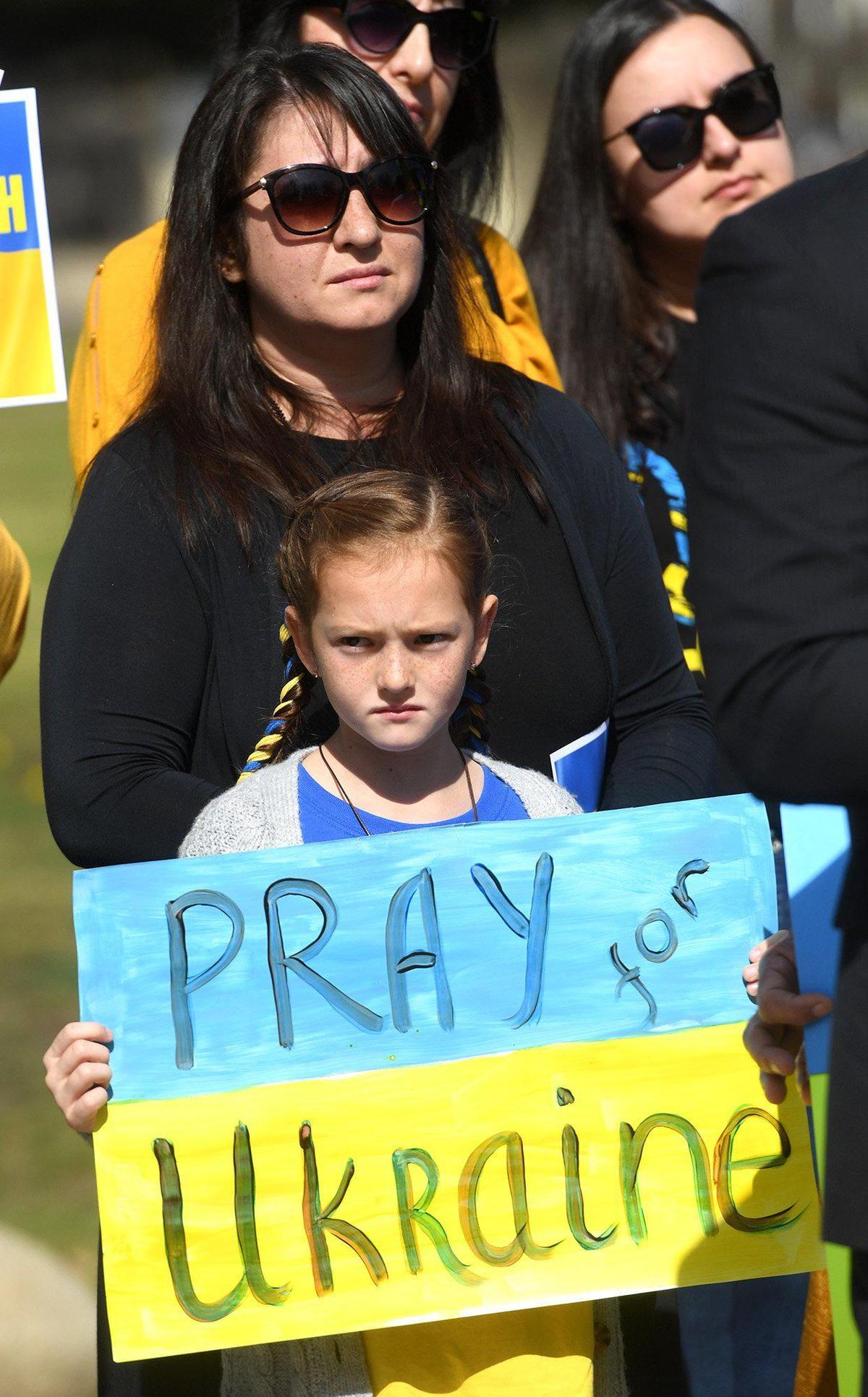 9-year-old Daniella Groth, whose family is from Ukraine, stands with others in support of the country, at a flag-raising ceremony, with the Ukrainian and American flags raised at Unity Park at Eaton Plaza, March 1, 2022, as a show of solidarity for the Ukrainian people.