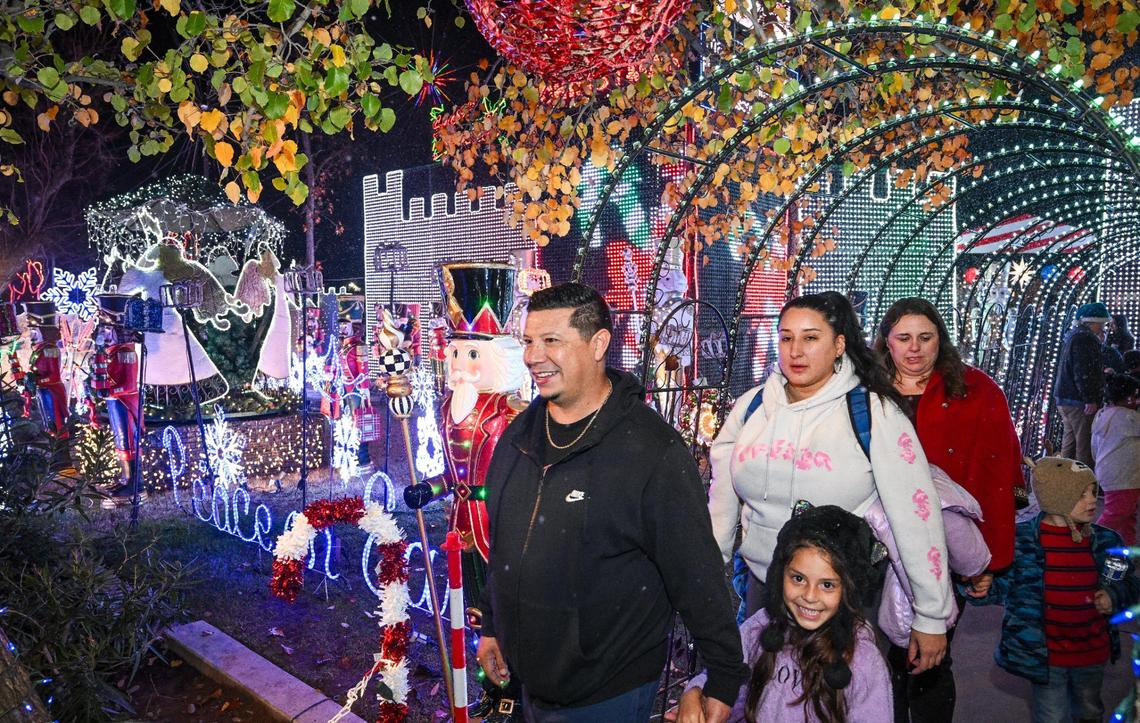 Holiday revelers walk through a display of lights at the Alexander home on Christmas Tree Lane south of Shaw in Fresno on the first of two walk-only nights on Tuesday, Dec. 3, 2024.