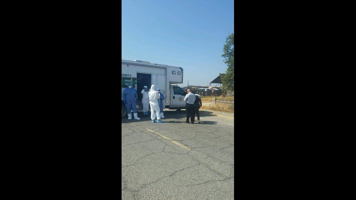 Deputies in Tulare County wear protective suits to investigate the deaths of two people inside a home near Tulare.