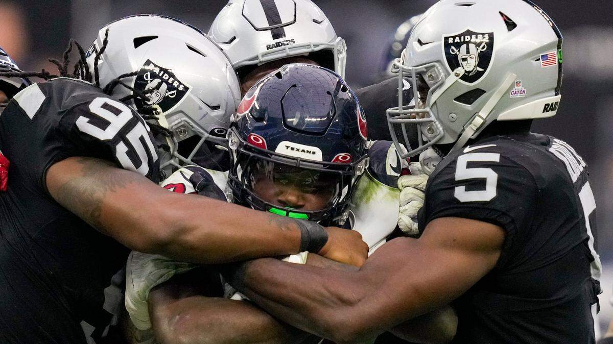 Houston Texans running back Dameon Pierce, center, is brought down by Las Vegas Raiders defensive tackle Kendal Vickers, linebacker Divine Deablo and others during the second half of an NFL football game Sunday, Oct. 23, 2022, in Las Vegas.