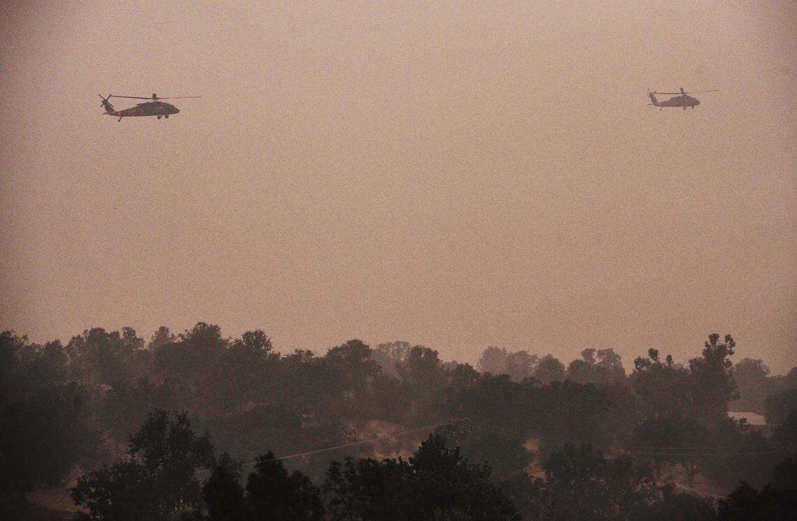 Air National Guard Blackhawk helicopters fly over a ridge at the Creek Fire north of Auberry Friday morning, Sept. 11, 2020.