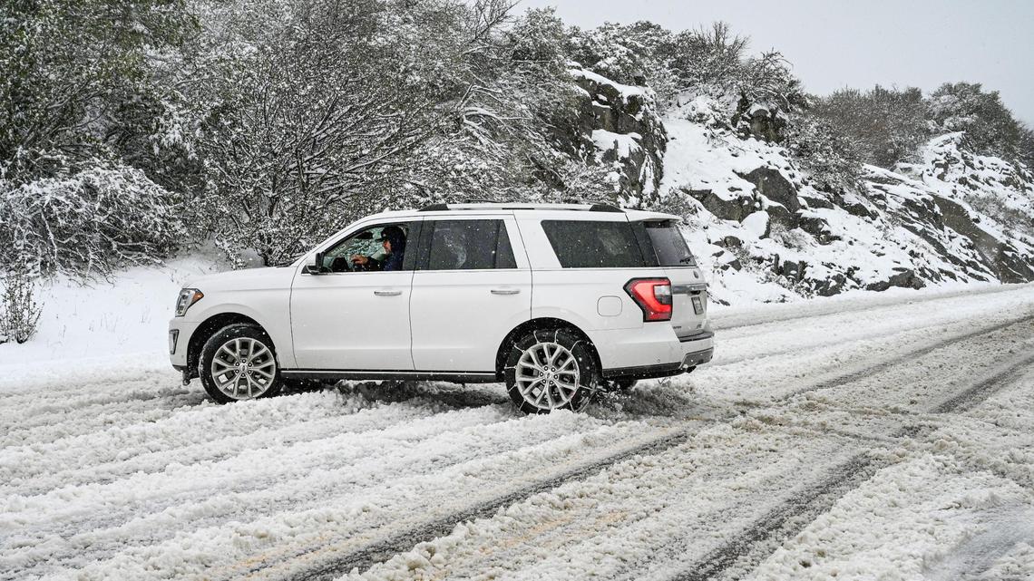 A vehicle turns around as snow builds up during a snowstorm on the four lane section of Highway 168 west of Pine Ridge on Monday, Dec. 27, 2021.