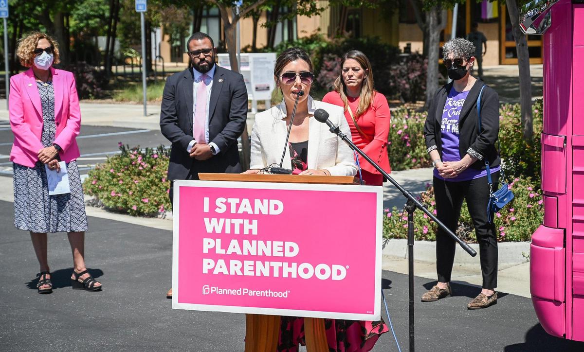 Jodi Hicks, CEO/President of Planned Parenthood Affiliates of California, backed by Stacy Cross, left, CEO/President of Planned Parenthood Mar Monte, Fresno city councilmembers Nelson Esparza and Esmeralda Soria, and Fresno Rabbi Laura Novak Winer, speaks during the Planned Parenthood Affiliates of California “Powered by Pink” Bus Tour stop at the Unitarian Universalist Church of Fresno on May 17, 2022.