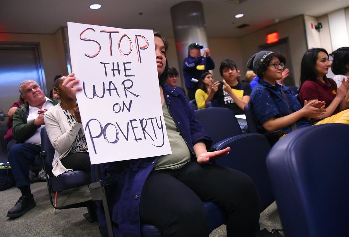 Julie Bounchareune holds a sign during the March 21 Fresno City Council meeting opposing a council proposal that would’ve made it illegal for drivers to give out handouts to panhandlers. The proposal was defeated.