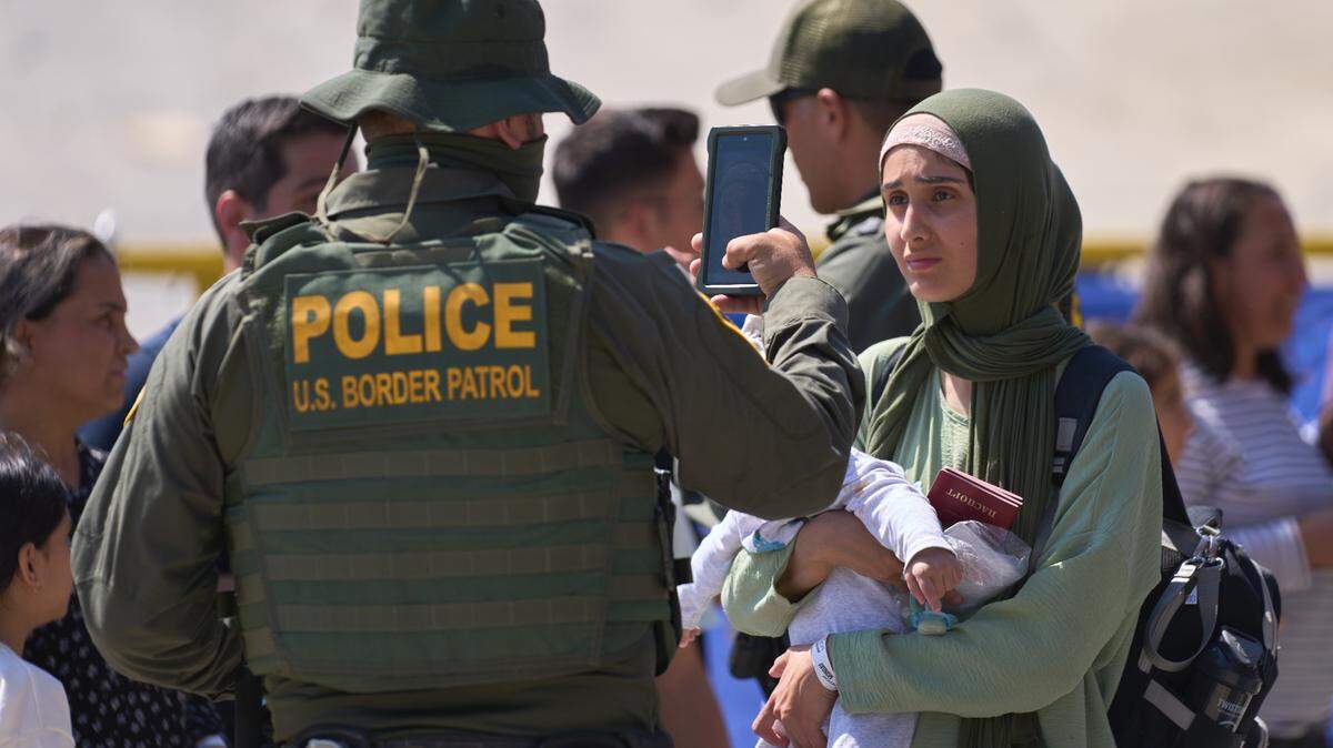 Una mujer es fotografiada durante el procesamiento por parte de la Patrulla Fronteriza de EE. UU. entre las dos vallas fronterizas en la frontera sur de EE. UU. con México en San Diego el 25 de septiembre.