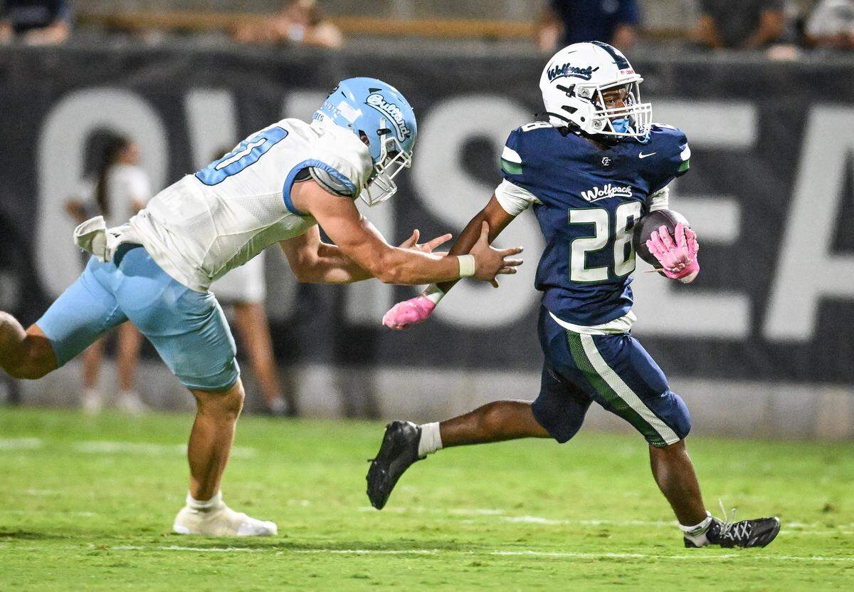 Clovis East's Ruben Molano, right, evades a tackle attempt from Bullard's Frankie McIntire during their game at Lamonica Stadium on Friday, Aug. 22, 2025.