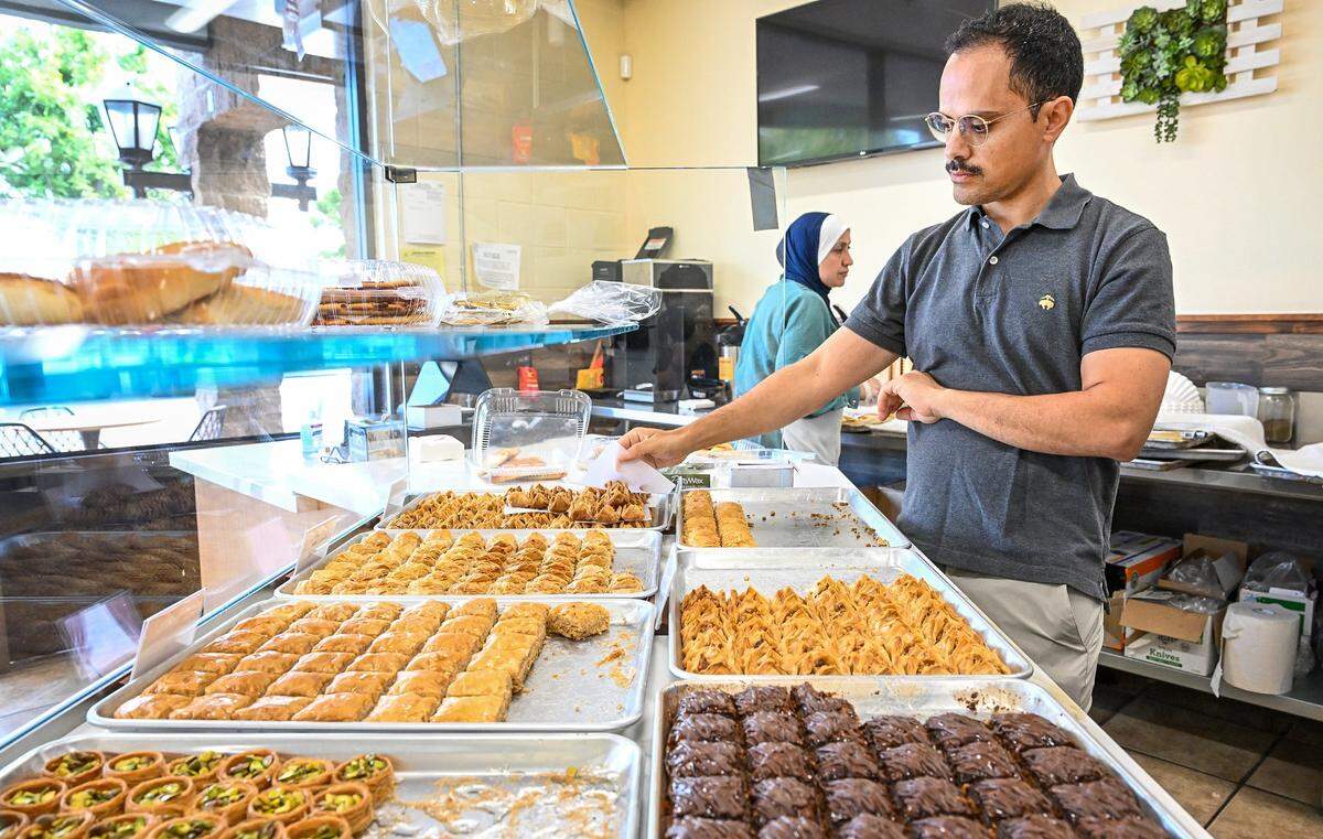 Hamed Alghazali, owner of Rumi Baklava, stands over trays of freshly made Middle Eastern pastries at the new bakery on West Shaw Avenue at Marks in Fresno on Tuesday, May 16, 2026. Alghazali, who owns Fabiano Coffee Roasters, is also planning to open a Mediterranean cafe on Fresno and Alluvial.