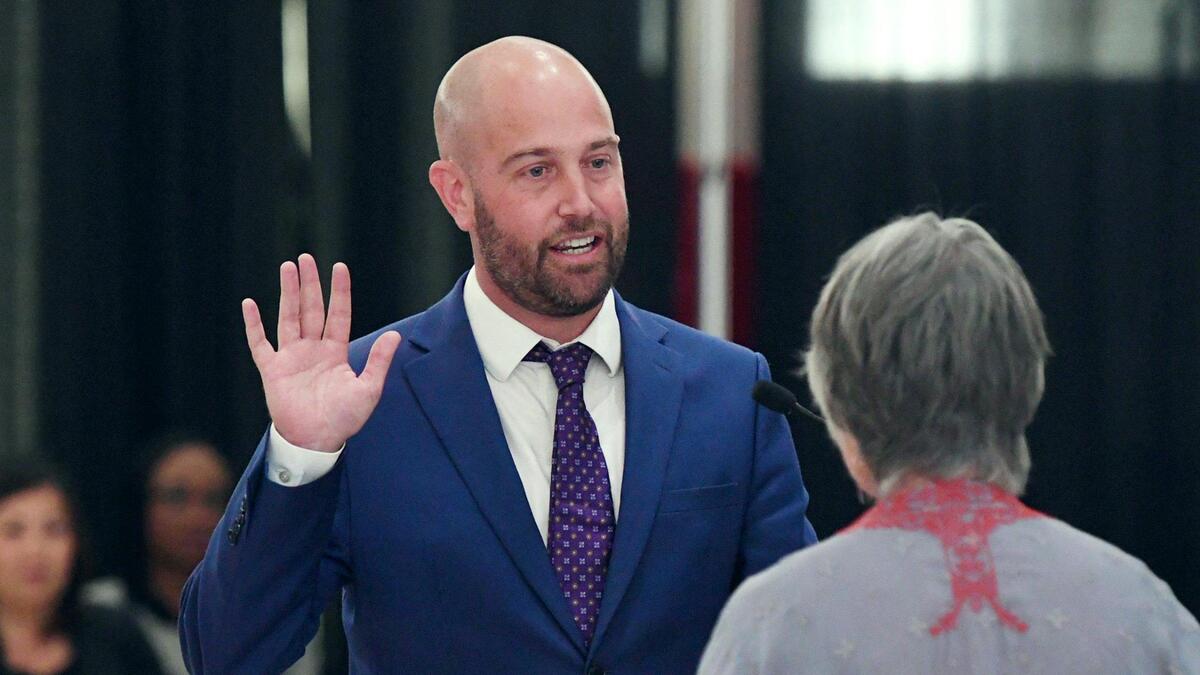 Andy Levine, left, is sworn in by his mother Trudi Thom, right, as the new Area 5 trustee on the Fresno Unified School Board in the McLane High cafeteria Wednesday afternoon, May 4, 2022 Fresno. Levine, who won in a special election in April 2022, takes the seat left by Carol Mills who passed away in July 2021.