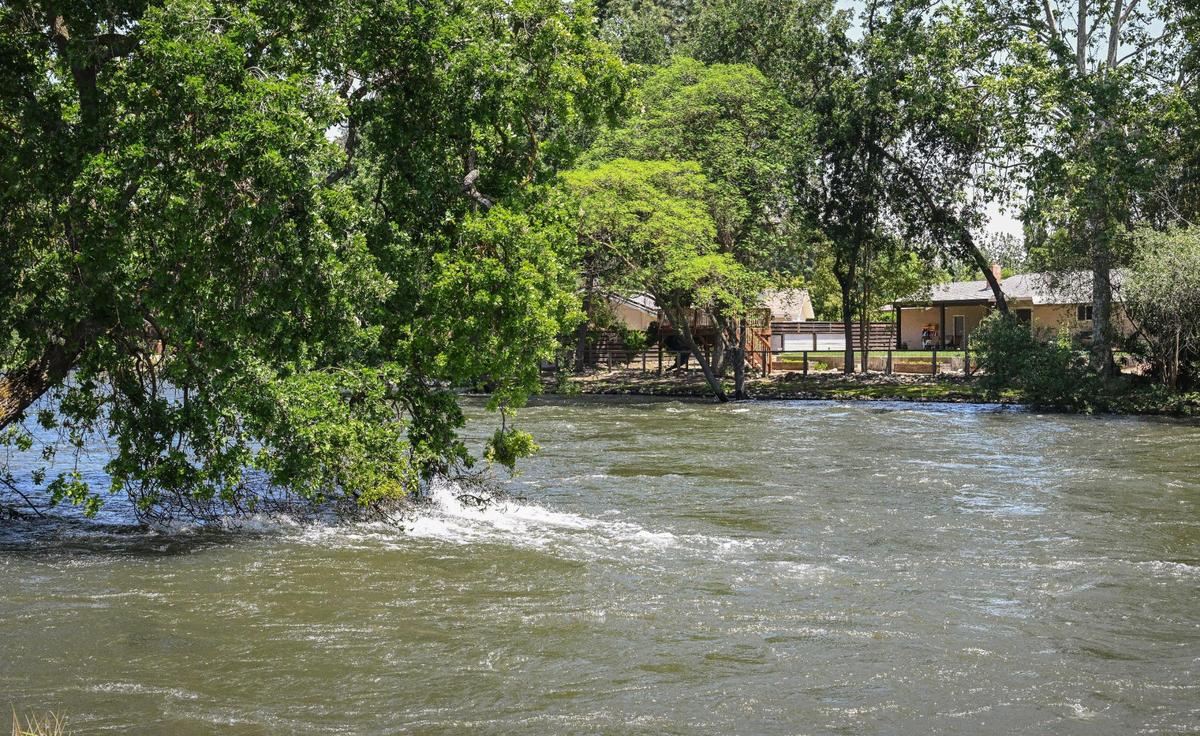 The Kings River flows at a high rate near a housing area north of Highway 180 and Piedra Road in eastern Fresno County on Wednesday, May 17, 2023. The River outflows are high due to heavy snowmelt in the Sierra Nevada.