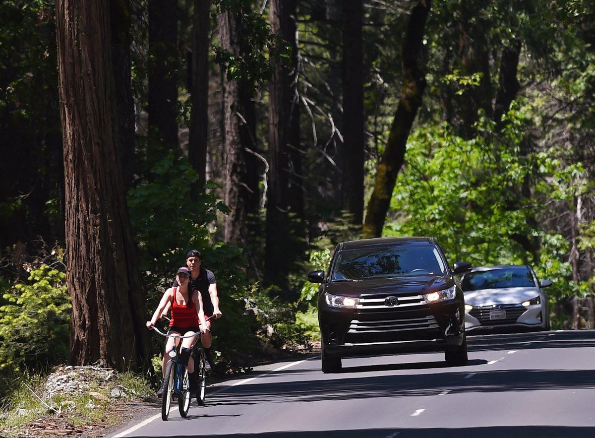 A couple ride bicycles along Southside Drive in Yosemite Valley Tuesday, June 4, 2019 in Yosemite National Park.