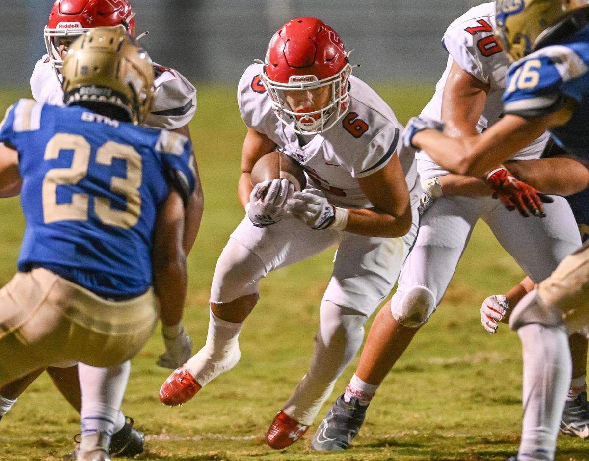 Sanger’s Conner Bohlken, center, looks for a gap on a run up the middle against Clovis during their game at Lamonica Stadium in Clovis on Friday, Aug. 25, 2023.