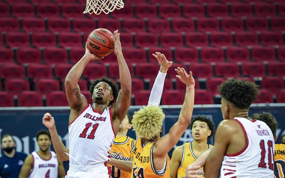 Fresno State’s Christian Gray, left, finds his way through the Wyoming defense for a layup during their game at the Save Mart Center on Monday, Jan. 4, 2021.