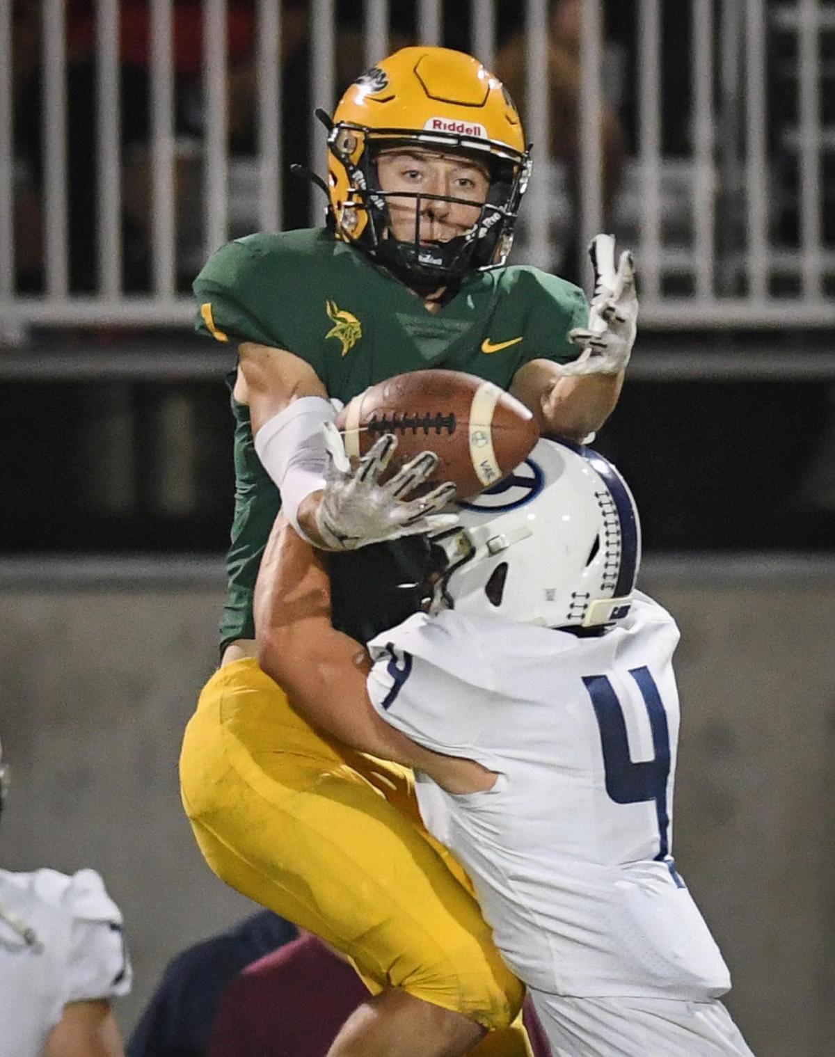 Kingsburg’s Conner McFall reaches over Central Valley Christian’s Cooper Noland for a catch down the sideline during their game at Kingsburg on Friday, Oct. 14, 2022.