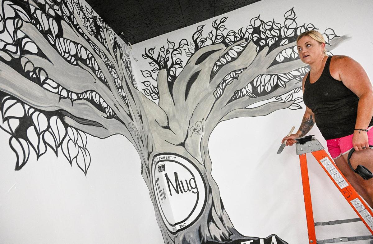 Muralist Jennifer Richards works on a tree mural for The Mug coffeehouse in the new Peacock Artisan Eatery, which is part of Peacock Market on the corner of Sunnyside and Tollhouse avenues in Clovis.