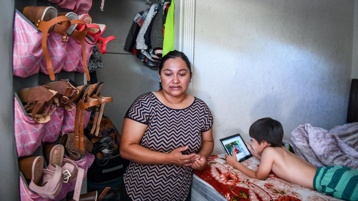 Juana, an undocumented mother of four living in Fresno, stands near the only closet at her house where all of her family’s clothing and shoes are kept.