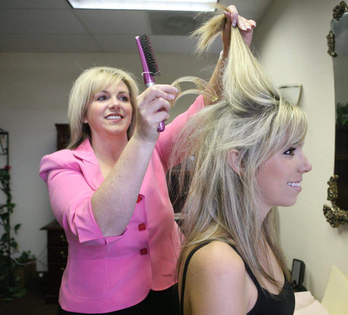FRESNO,CA-- - BIZ TAO BUMPITS 1 -- - Kelly Fitzpatrick puts in a Bumpits into her daughters Katherine Dias’ hair to give it elevation and body. Fitzpatrick is a hairdresser turned mortgage banker and when the mortgage business went South she started her own business making and selling bumpits on the Home Shopping Network in Australia and the U.S. Tomas Ovalle/ The Fresno Bee