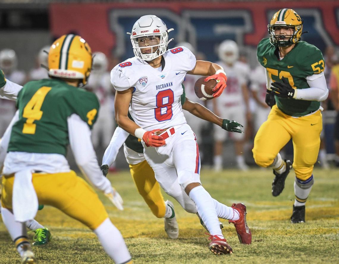 Buchanan’s Josiah Ayon, center, weaves his way through the Kingsburg defense on his way to an early touchdown during their game at Kingsburg High on Friday, Aug. 20, 2021.