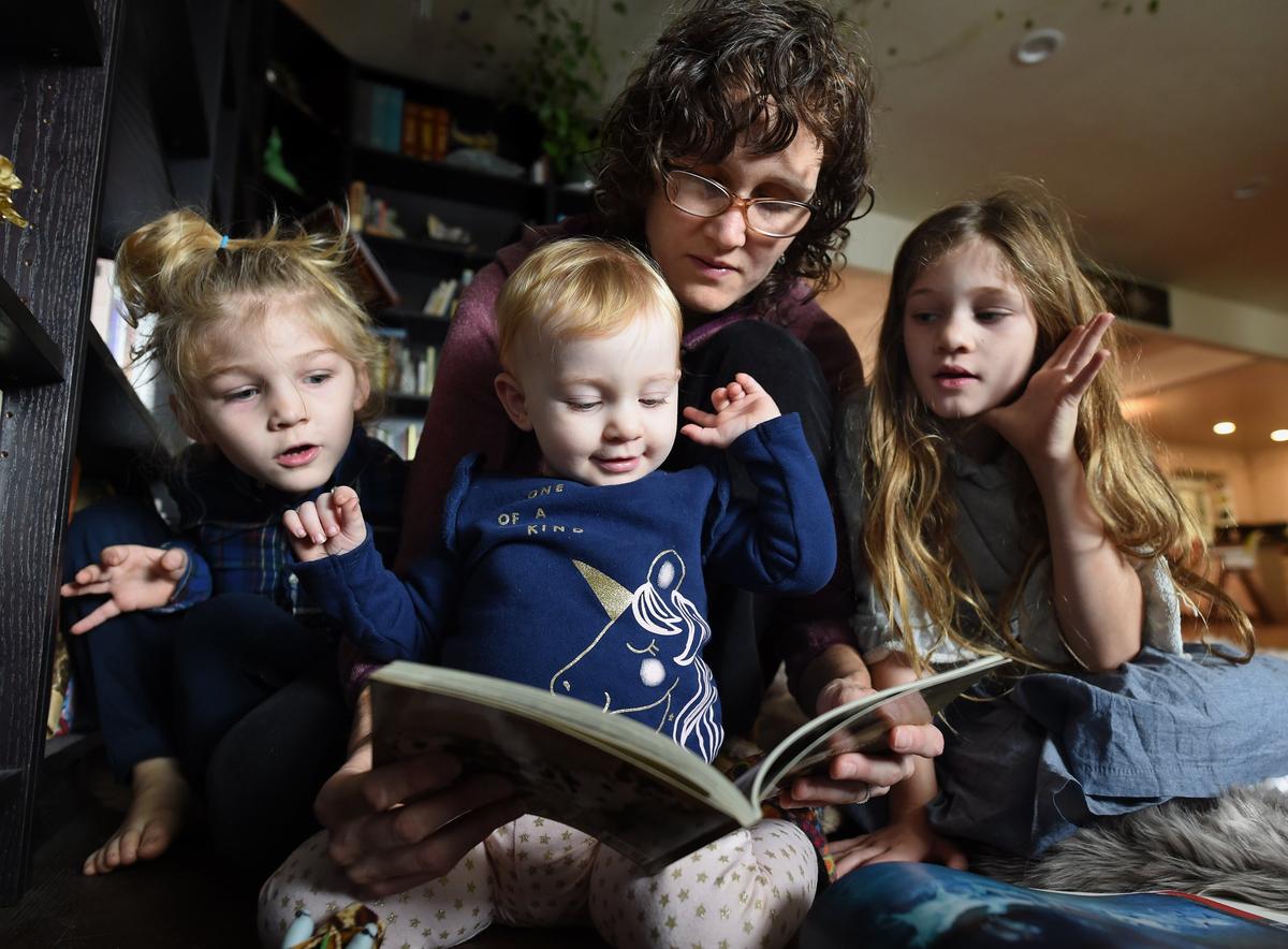 Christa Pehl Evans explores a book with her children from left, Harvey, 5, 15-month-old Sylvia, and 7-year-old Violet. Pehl Evans says she was berated and humiliated by Fresno County Superior Court Judge James Petrucelli during jury duty selection after she asked to be excused to care for her children.