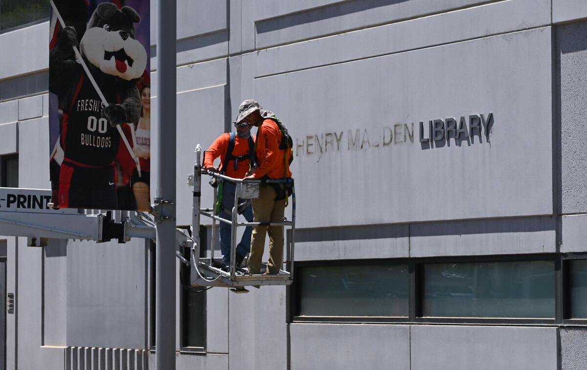 Workers complete the removal of Henry Madden’s name from the east side of Fresno State’s library Wednesday, July 20, 2022 in Fresno. The California State University system’s board of trustees approved the removal of Madden’s name from Fresno State’s University Library, following discovery of his deeply held anti-Semitic views and Nazi sympathies. Lisa Bell, with Fresno State Communications, said a naming task force will be created to determine a new name which may take a year to finalize.