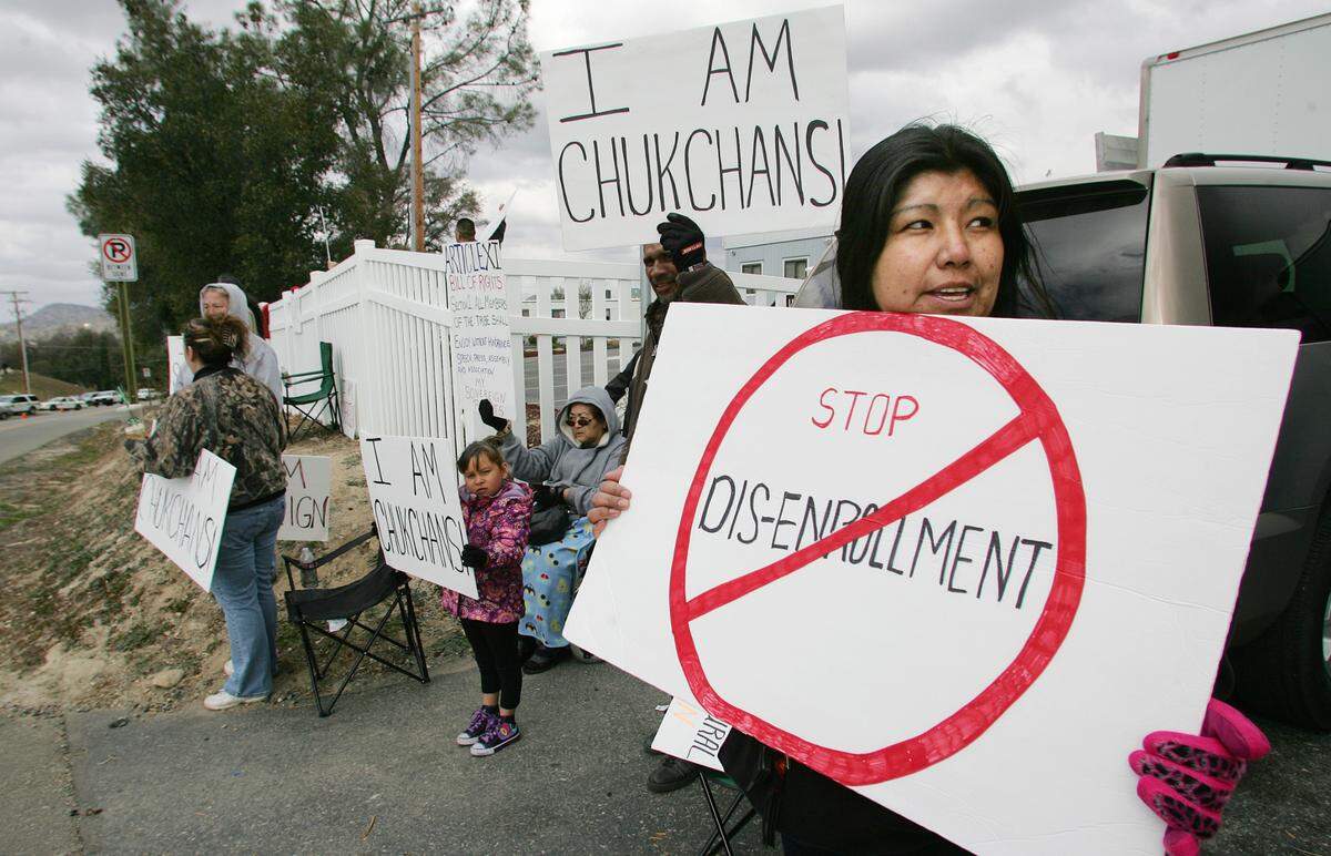 Protesters in February 2012 hold signs against disenrollments outside the Picayune Rancheria of the Chukchansi Indians’ tribal offices in Coarsegold, then located across the street from Chukchansi Gold Resort & Casino.