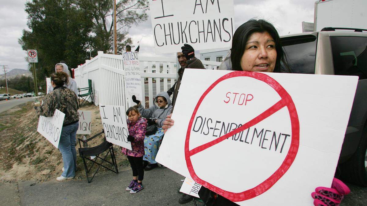 Protesters in February 2012 hold signs against disenrollments outside the Picayune Rancheria of the Chukchansi Indians’ tribal offices in Coarsegold, then located across the street from Chukchansi Gold Resort & Casino.
