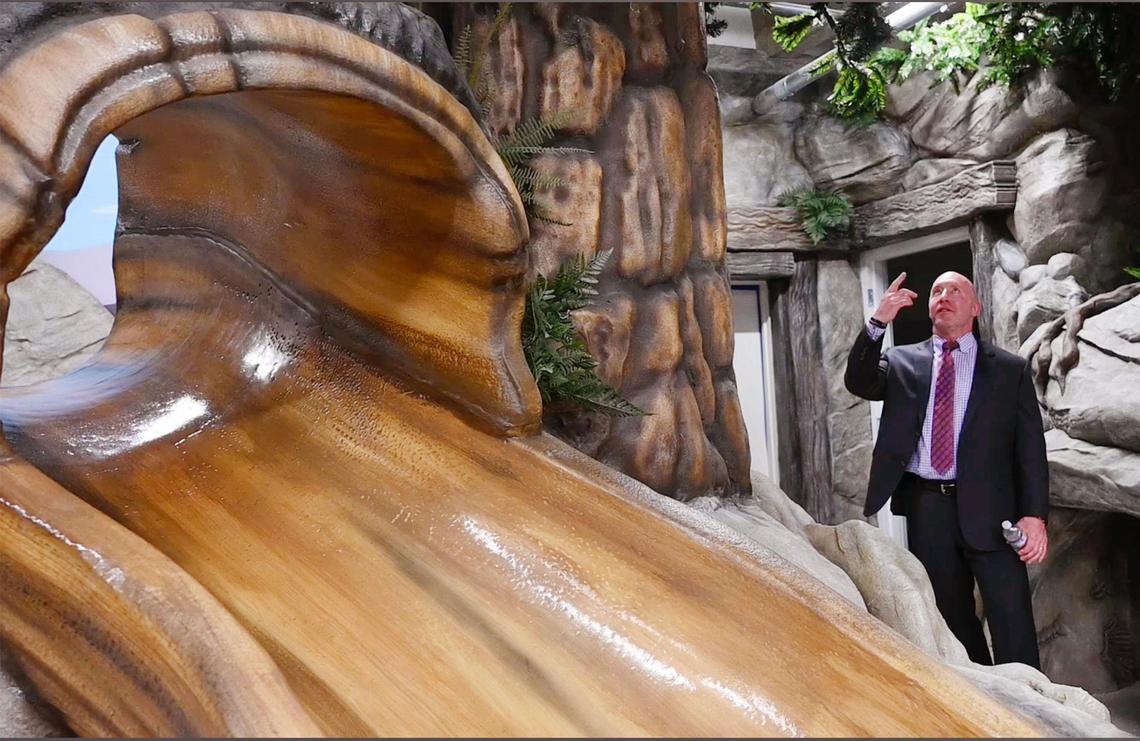 Mark Riley, CEO of Bank of America Fresno/Visalia, takes a look at the replicated forest in a playroom for children which features a slide, left, during a tour of The Fresno Mission’s new Heartbeat Hub Wednesday, Oct. 12, 2022 in Fresno.
