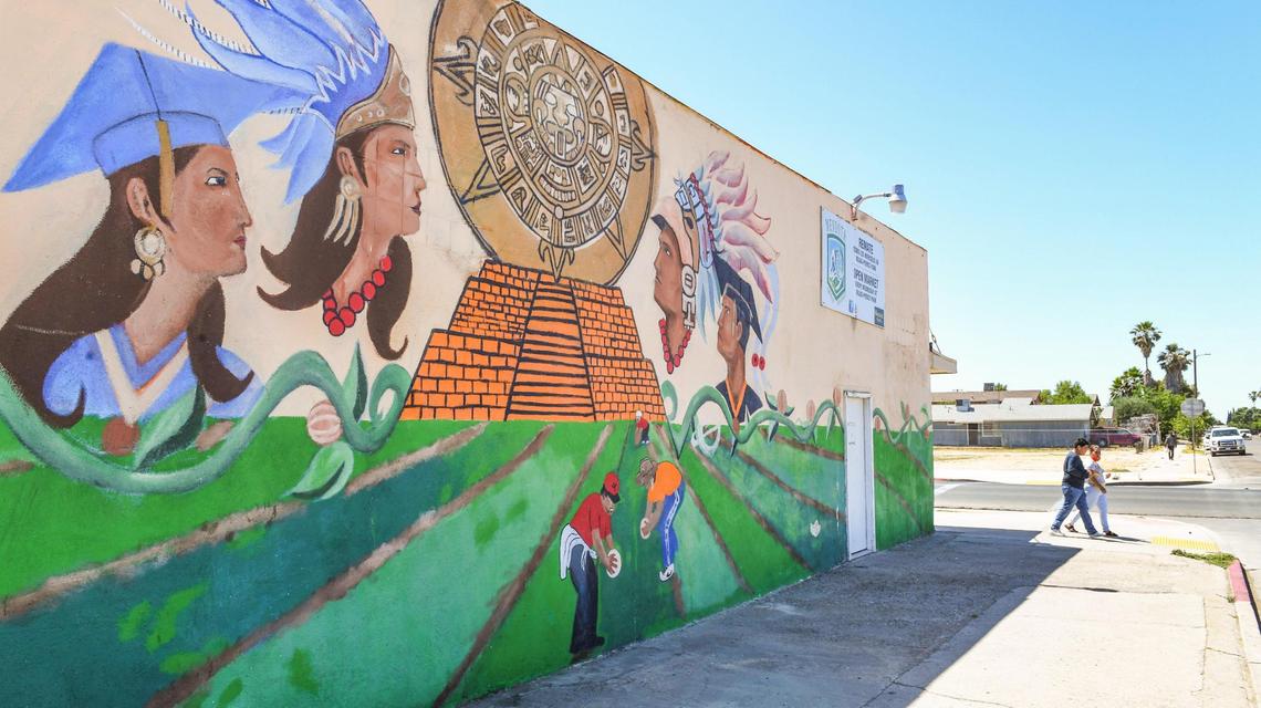 An Aztec-themed mural with farmworkers picking cantaloupes appears on the side wall of the Westside Youth Center on 7th Street in Mendota on Thursday, June 10, 2021.