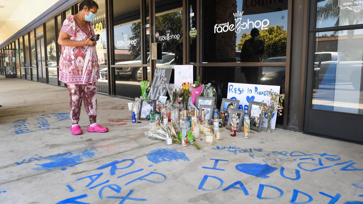 A woman stops by to pay her respects at a memorial memorial for 23-year-old Alex Solorio of Stratford outside Colima’s Fade Shop at Blackstone and Herndon avenues on Wednesday, June 2, 2021. Solorio was found dead inside the barbershop last Sunday.
