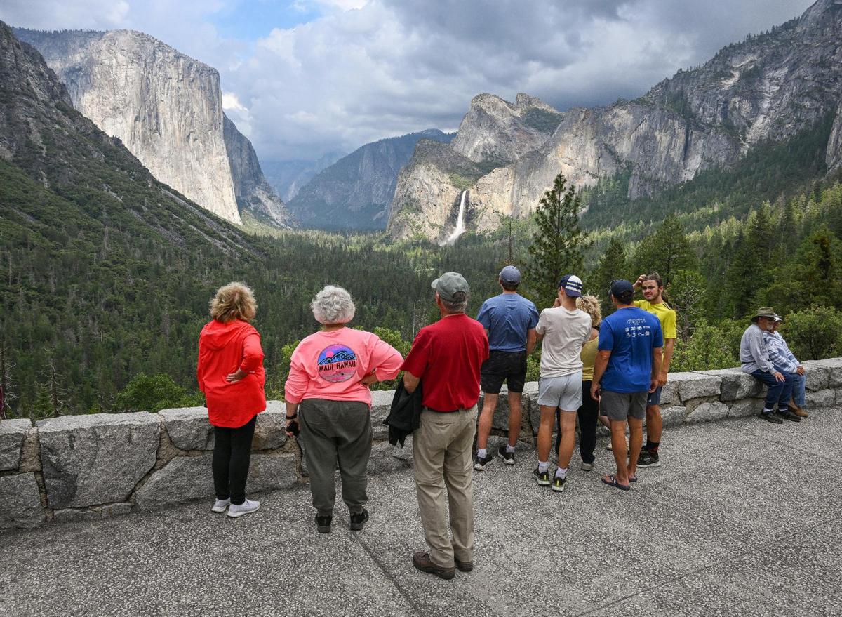 Yosemite National Park visitors take a look at El Capitan rock formation, left, and Bridalveil Fall from Tunnel View in Yosemite Valley on Tuesday, June 13, 2023.
