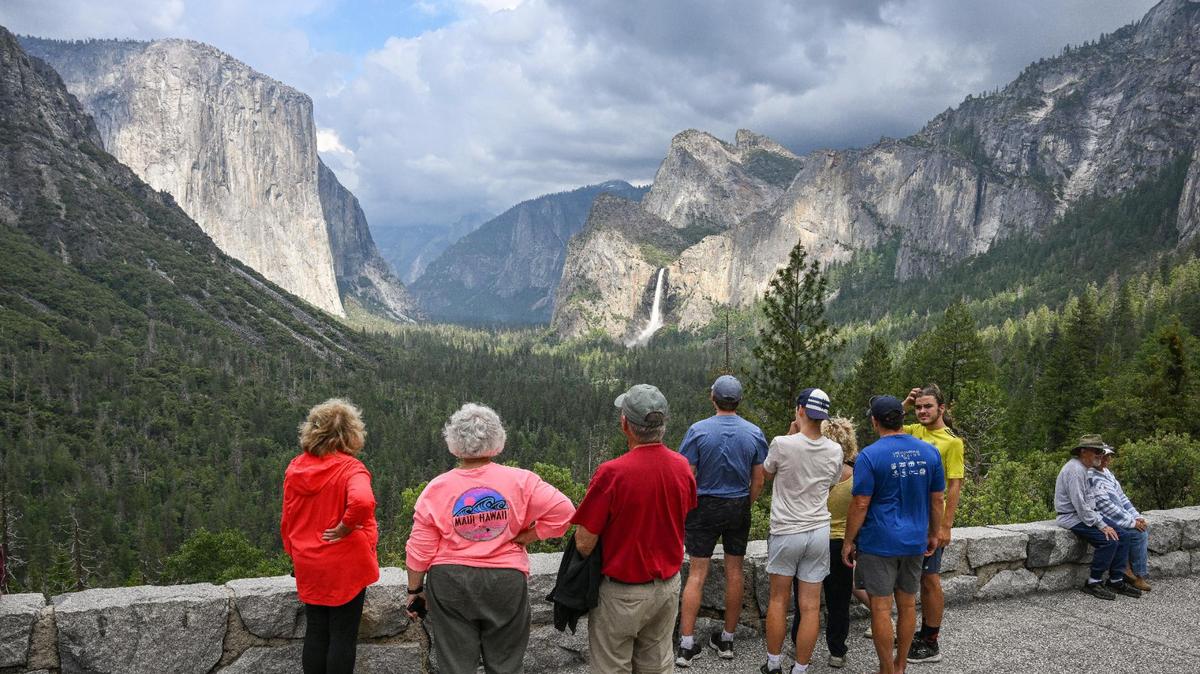 Yosemite National Park visitors take a look at El Capitan rock formation, left, and Bridalveil Fall from Tunnel View in Yosemite Valley in 2023.