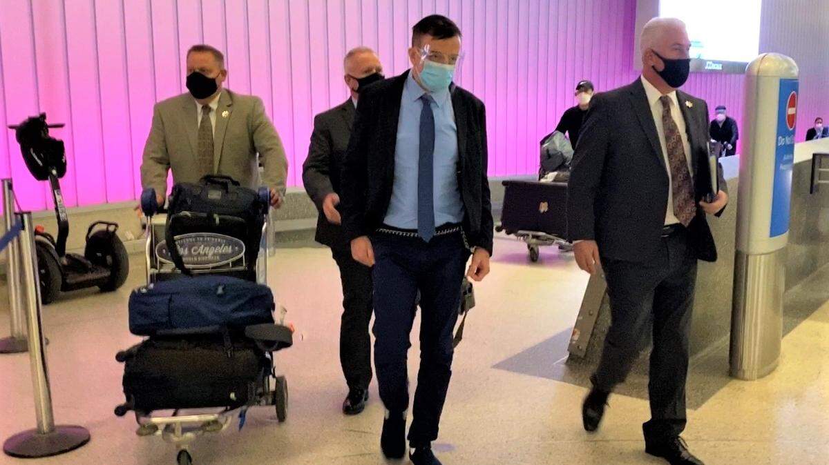 Tulare County District Attorney investigators take Dr. Benny Benzeevi into custody at Los Angeles International Airport on December 3, 2020.